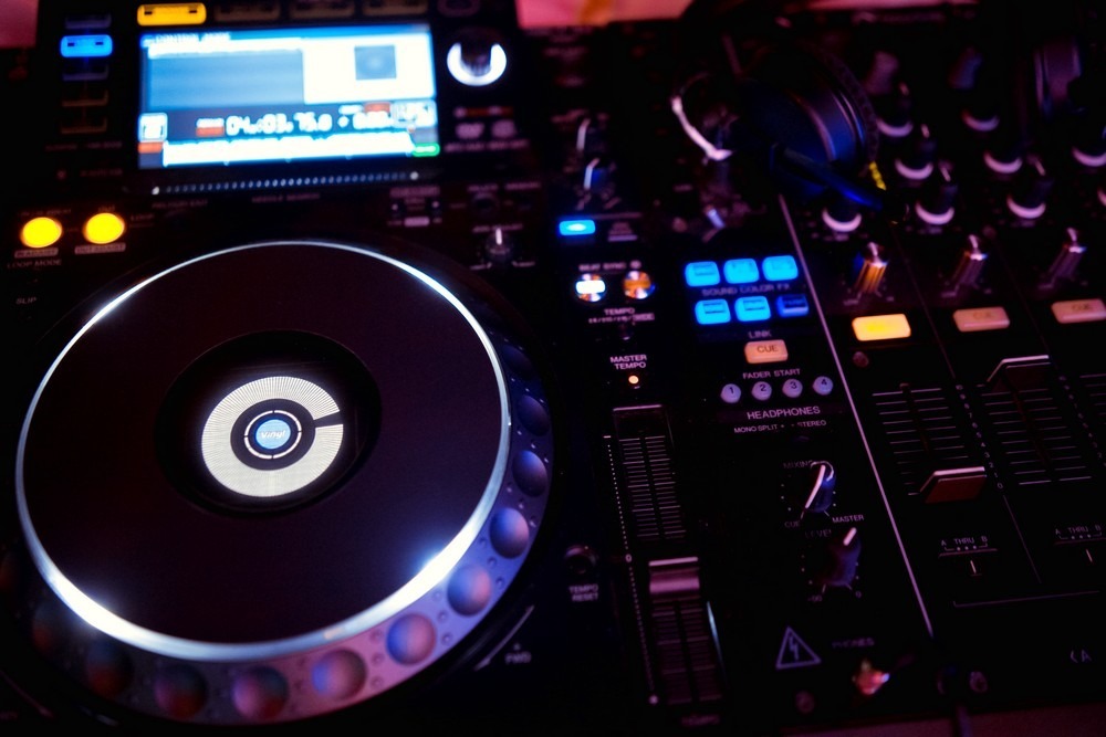 DJ sound equipment at nightclubs and music festivals, EDM, future house music and so on. Parties concept, sound technique. DJ playing on the best, famous CD players.